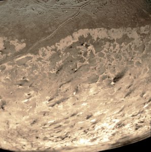 Rastros oscuros en el polo sur de Tritón. Probablemente, depósitos de partículas de antiguas erupciones de nitrógeno