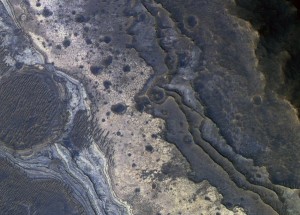 Esta imagen, tomada por la Mars Orbiter, muestra capas de roca en el sistema de cañones de Valle Marineris. En ella se pueden apreciar tramos de silicio opalino, como el fotografiado por el rover Spirit en el Cráter Gusev. Crédito: NASA/JPL-Caltech/Univ. of Arizona