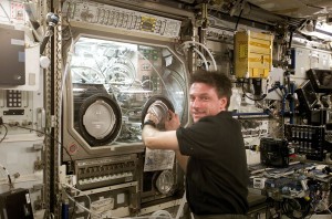 El comandante de la expedición 8, Michael Foale, examina la caja de guantes de microgravedad en la Estación Espacial Internacional. Crédito: NASA/Crew of Expedition 8