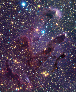 Esta imagen en infrarrojo nos permite ver con mucho más detalle cómo es la zona de los Pilares de la Creación, y también su interior. Es una zona repleta de estrellas, tanto a su alrededor, como en el interior de los glóbulos. Crédito: ESO