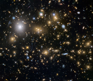 Las observaciones del telescopio Hubble, recurriendo a la técnica de lente gravitacional, han revelado uno de los grupos más grandes de las primeras galaxias (y más tenues) del universo. Algunas de ellas se formaron sólo 600 millones de años después del Big Bang. Crédito: ESA/NASA 